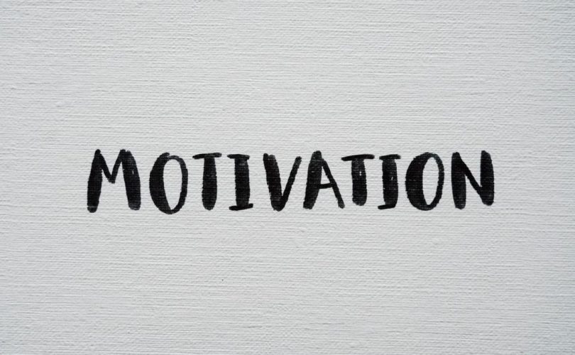 Inspirational word 'Motivation' in black on a white textured canvas background.